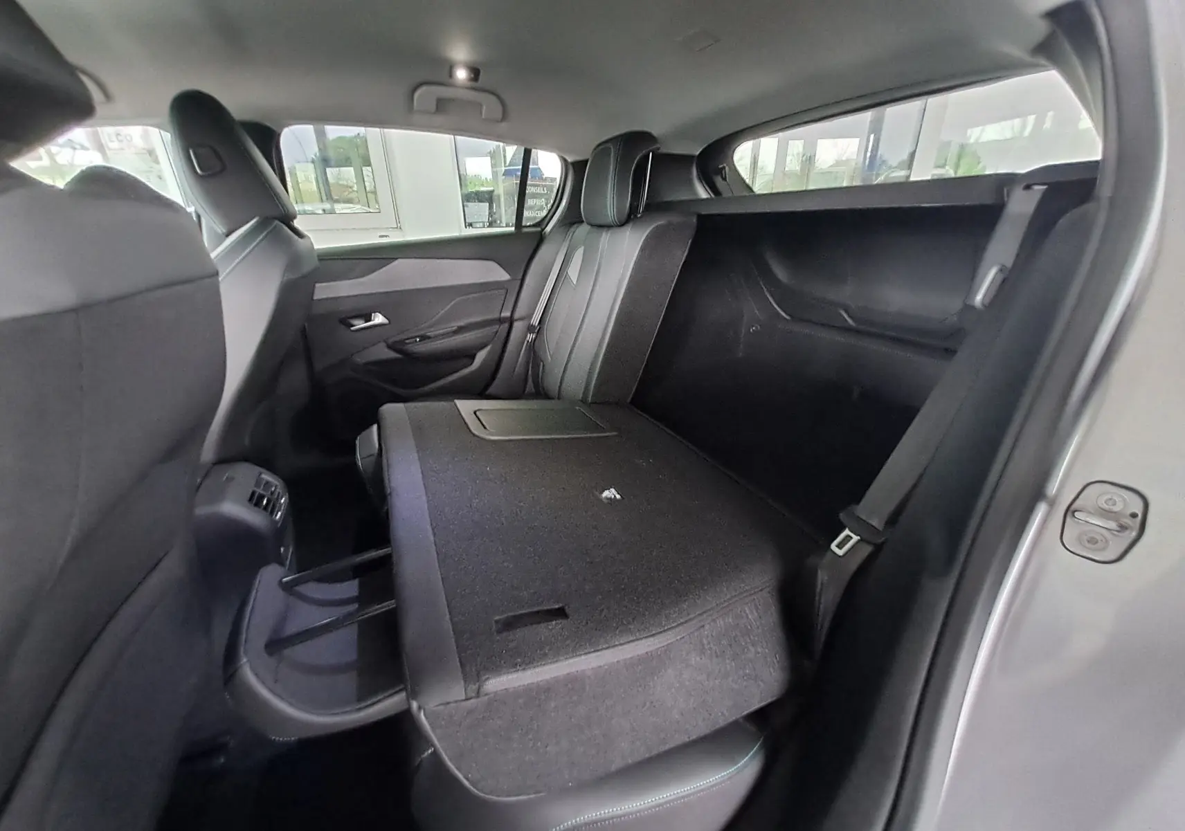 Intérieur arrière de la Peugeot 308 gris Artense 2023, siège arrière gauche rabattable, vue côté droit ouvert.