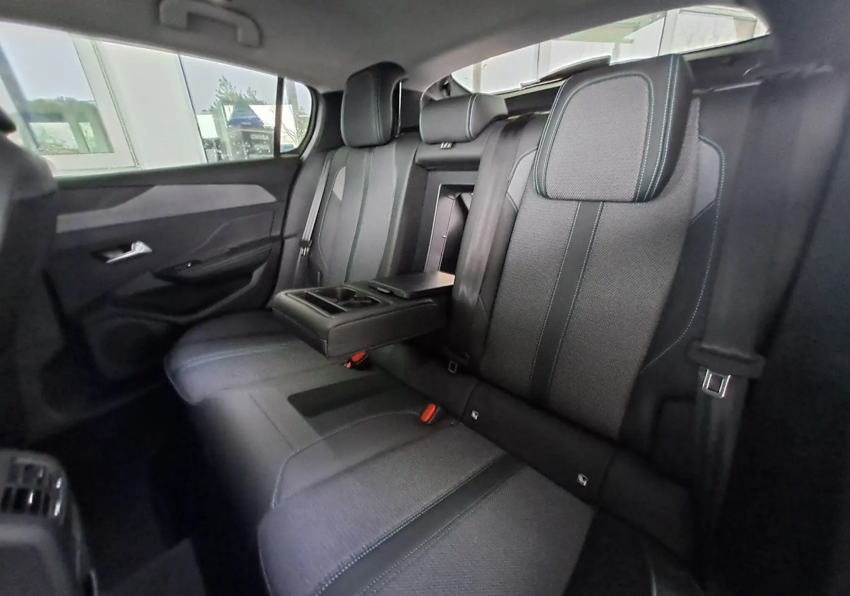 Vue intérieure arrière côté gauche des sièges gris foncé avec accoudoir central déplié de la Peugeot 308 2023