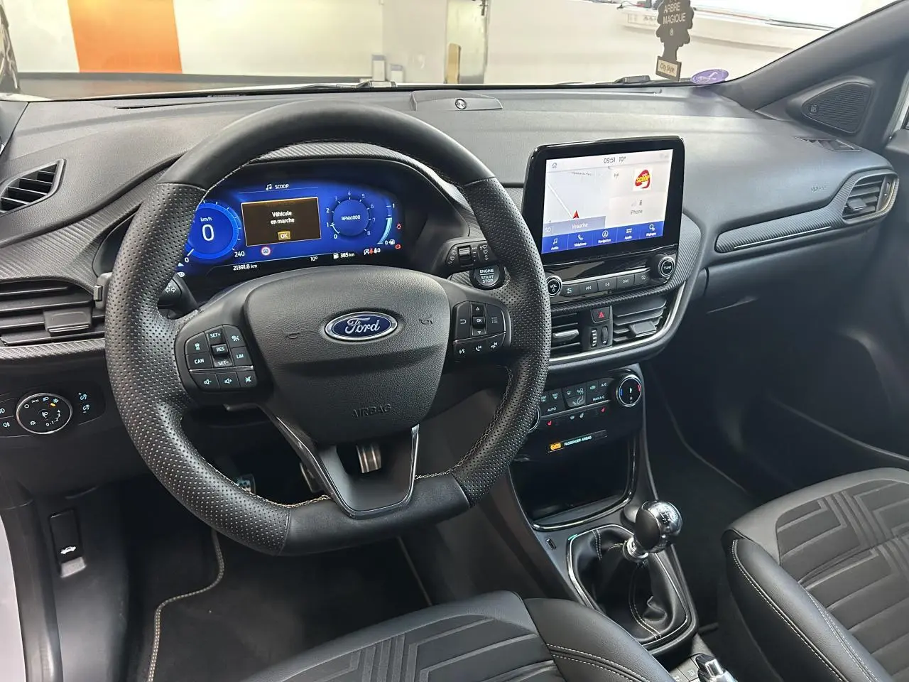 Intérieur du Ford Puma 2023 gris, vue du poste de conduite avec volant multifonction et écran tactile central.