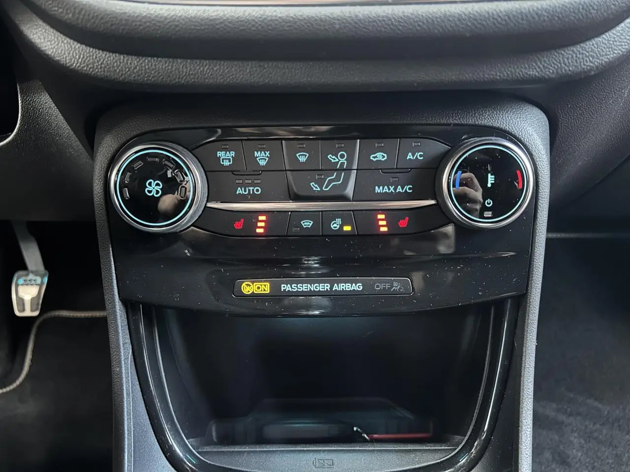 Vue rapprochée de la console centrale du Ford Puma gris 2023, avec commandes climatisation et sièges chauffants activés.