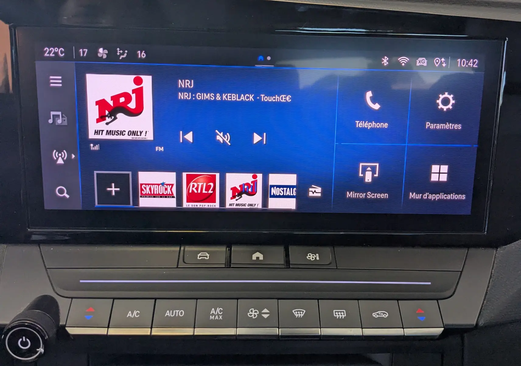 Écran tactile central de l'Opel Astra 2022 affichant la radio NRJ avec commandes climatisation en dessous.