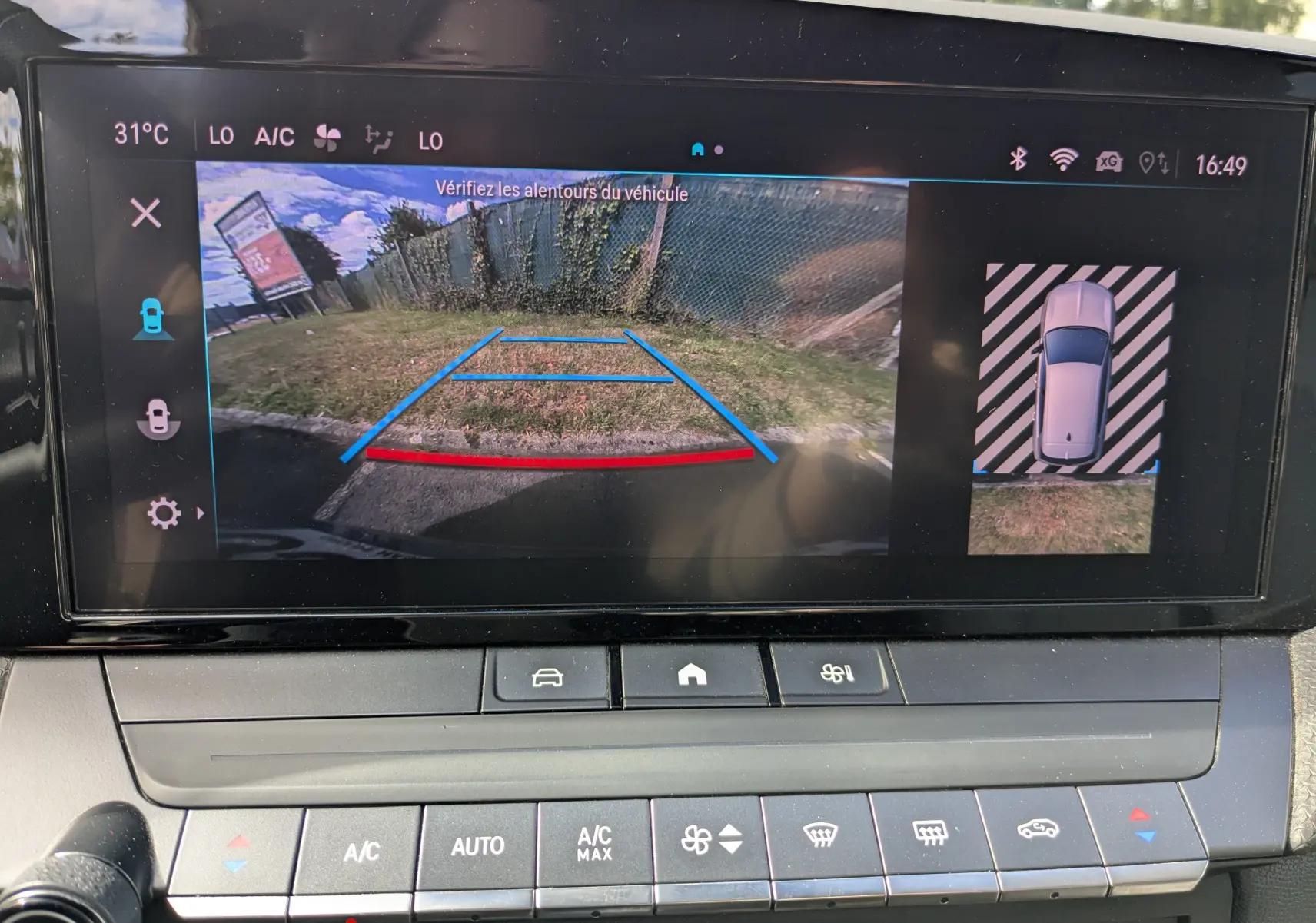 Vue de l'écran multimédia de l'Opel Astra bleu 2022 montrant la caméra de recul avec guidage de trajectoire coloré.