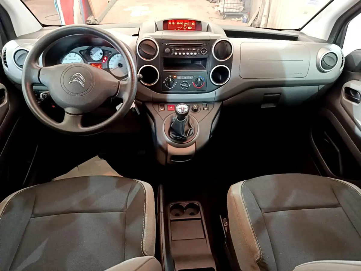 Vue intérieure avant du Citroën Berlingo 2016 avec tableau de bord gris et volant noir à boîte manuelle.