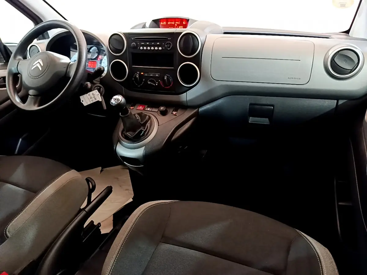 Intérieur du Citroën Berlingo 2016, vue du tableau de bord et volant côté conducteur, sièges noirs.