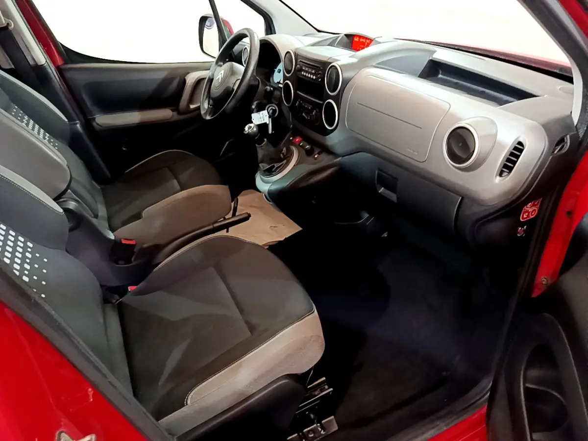 Intérieur du Citroën Berlingo rouge 2016, vue côté conducteur, tableau de bord et sièges avant en tissu gris.