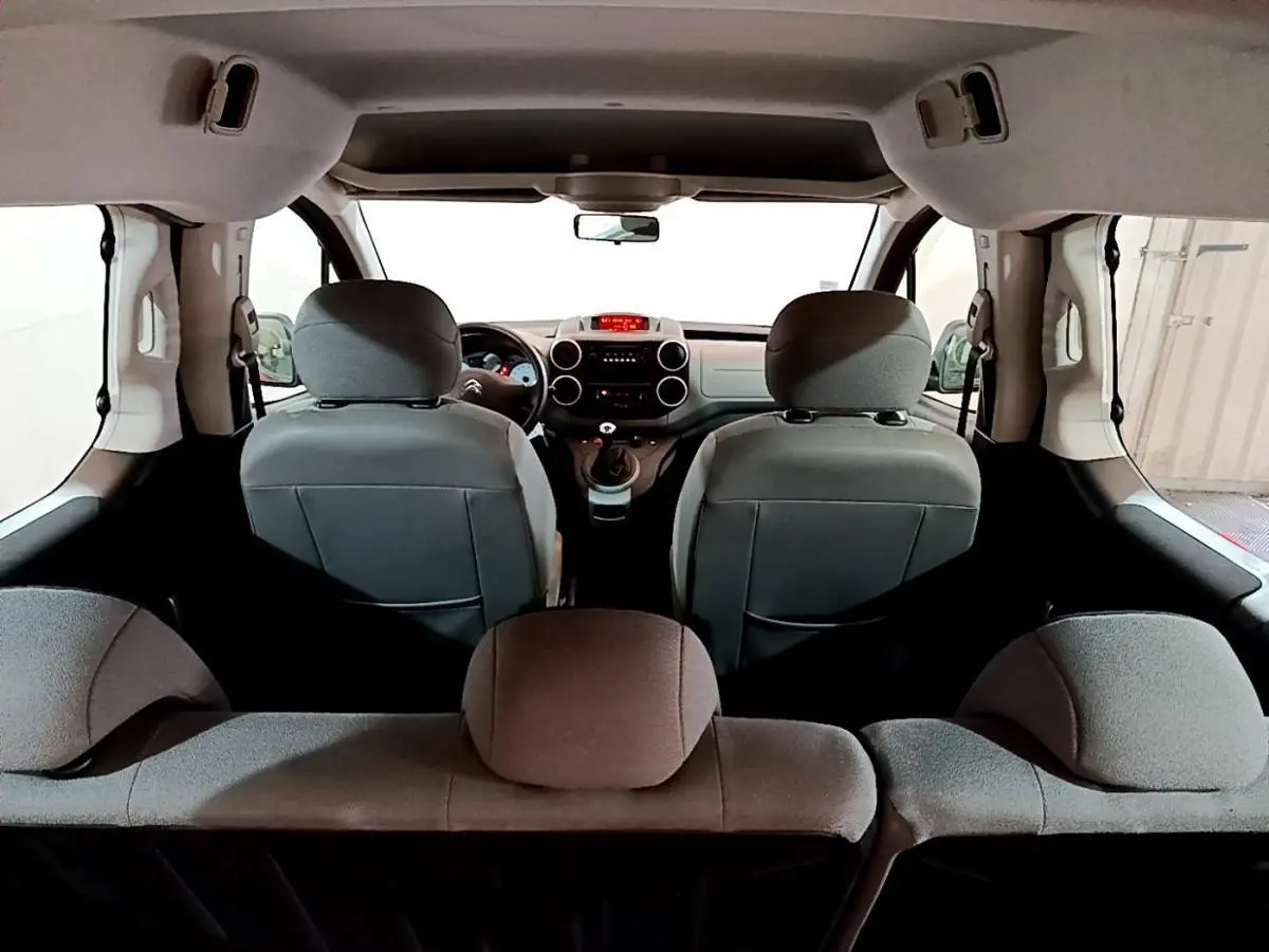 Vue intérieure arrière du Citroën Berlingo BlueHDi 75 BVM Feel 2016, sièges gris et tableau de bord visible.