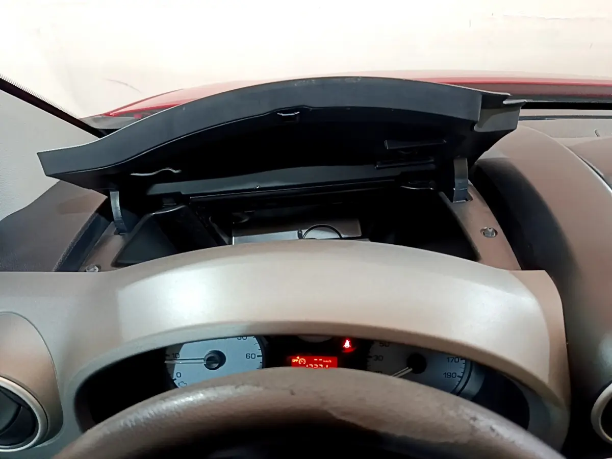 Vue intérieure centrée sur le tableau de bord et le volant beige du Citroën Berlingo rouge de 2016.