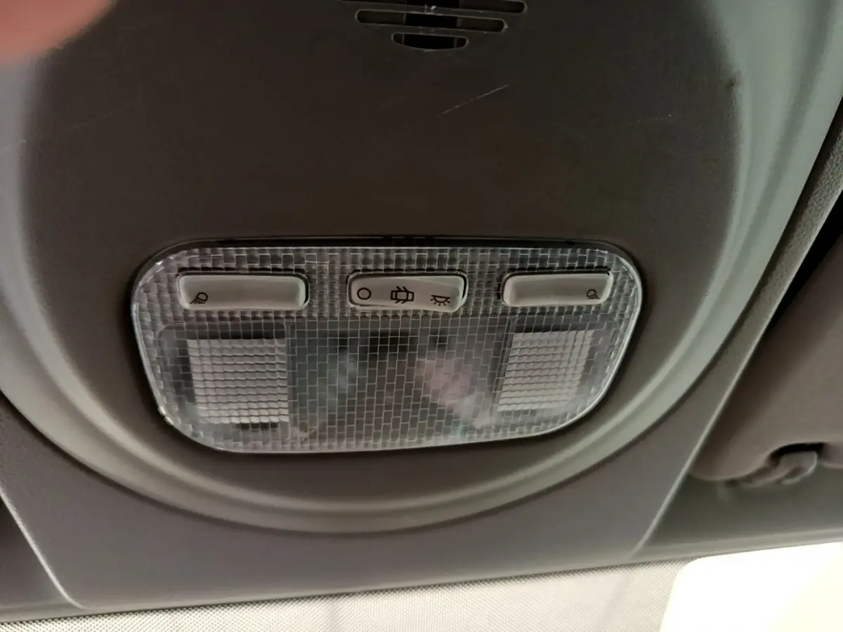 Plafonnier intérieur avec trois boutons de commande, dans un Citroën Berlingo rouge de 2016.