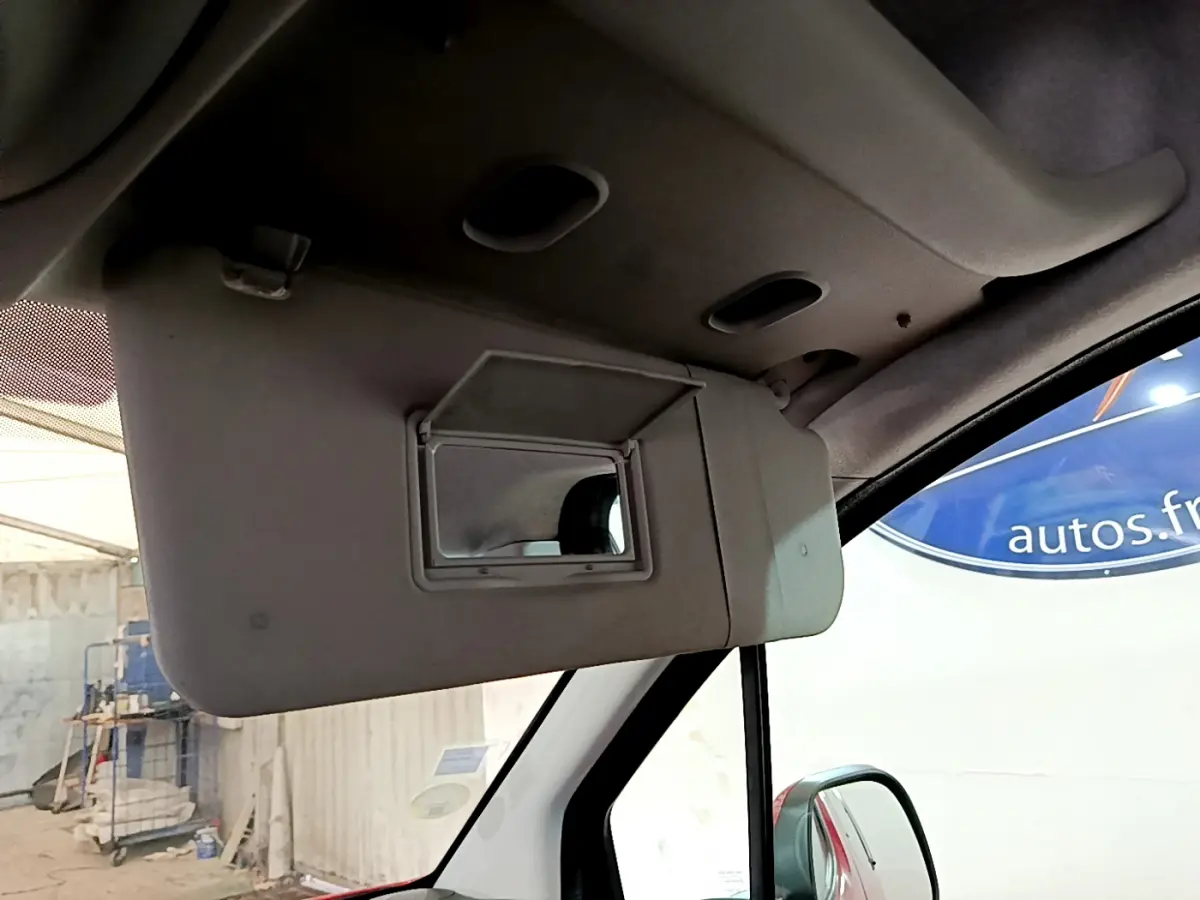 Miroir de courtoisie ouvert sur le pare-soleil côté conducteur dans l'habitacle d'un Citroën Berlingo rouge 2016.