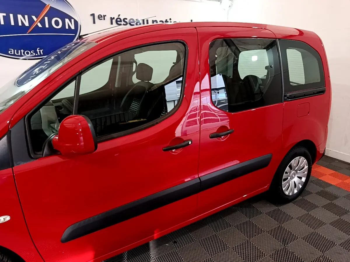 Vue latérale gauche d'un Citroën Berlingo rouge 2016 avec poignées et rétroviseurs assortis, intérieur visible.