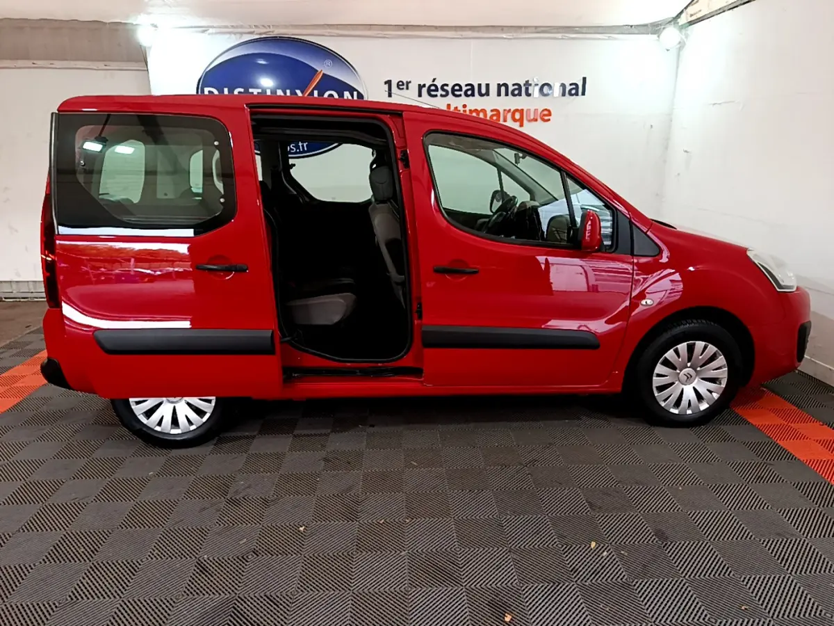 Profil côté gauche d'un Citroën Berlingo rouge 2016 avec porte coulissante arrière ouverte, intérieur visible.