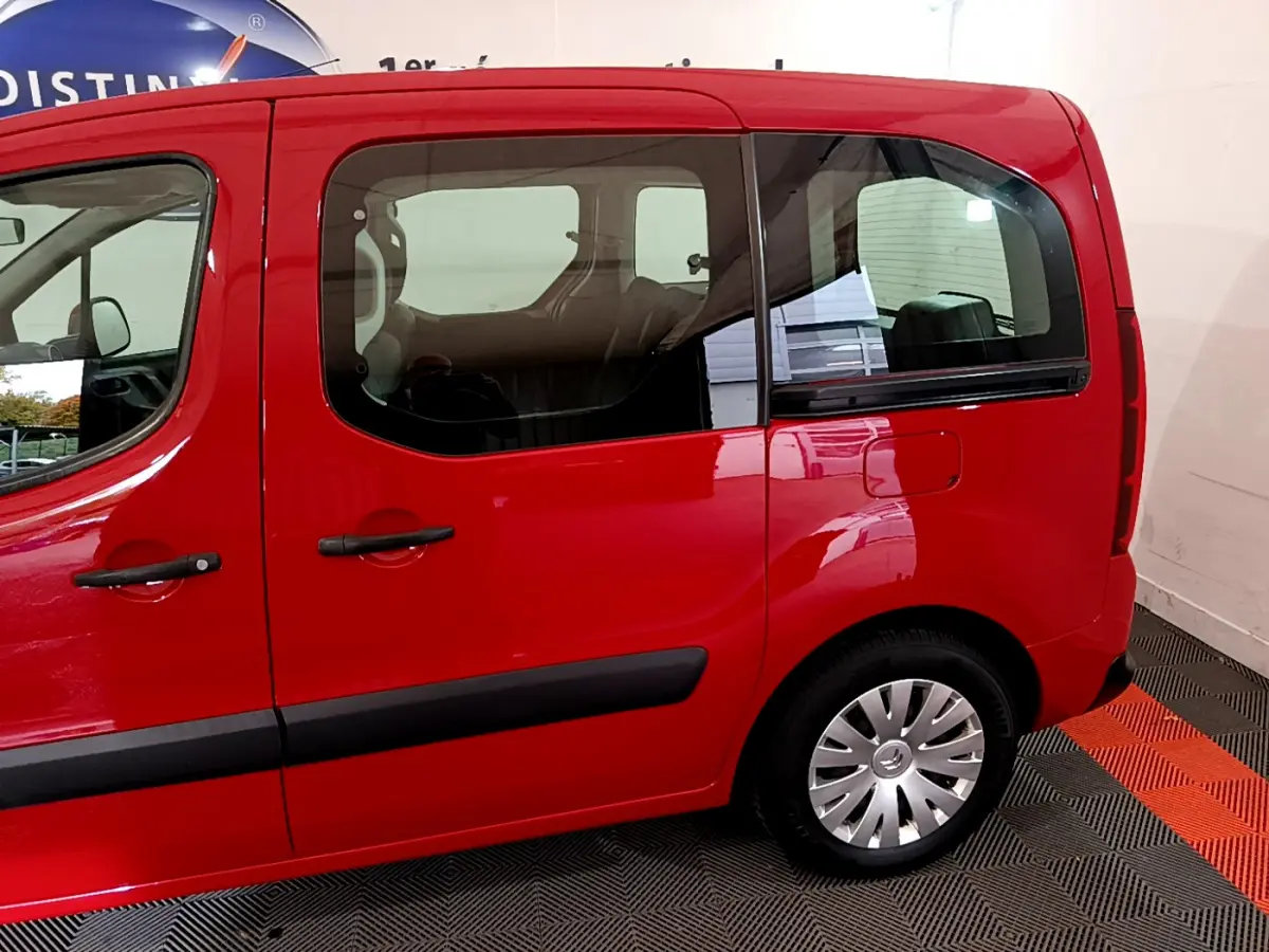 Profil côté gauche du Citroën Berlingo rouge 2016, mettant en valeur ses portes coulissantes et fenêtres arrière larges.