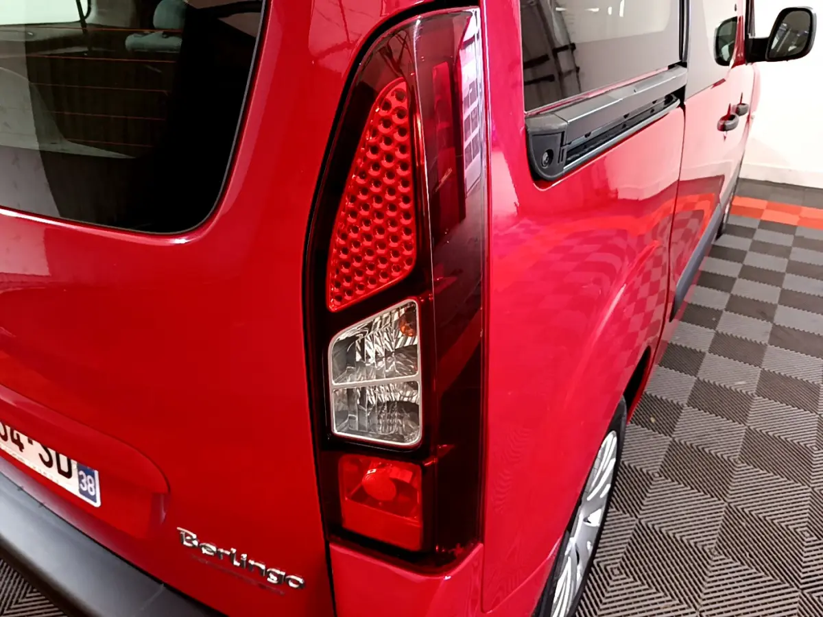 Vue 3/4 arrière droite du Citroën Berlingo rouge mettant en valeur son feu arrière vertical et sa vitre latérale.