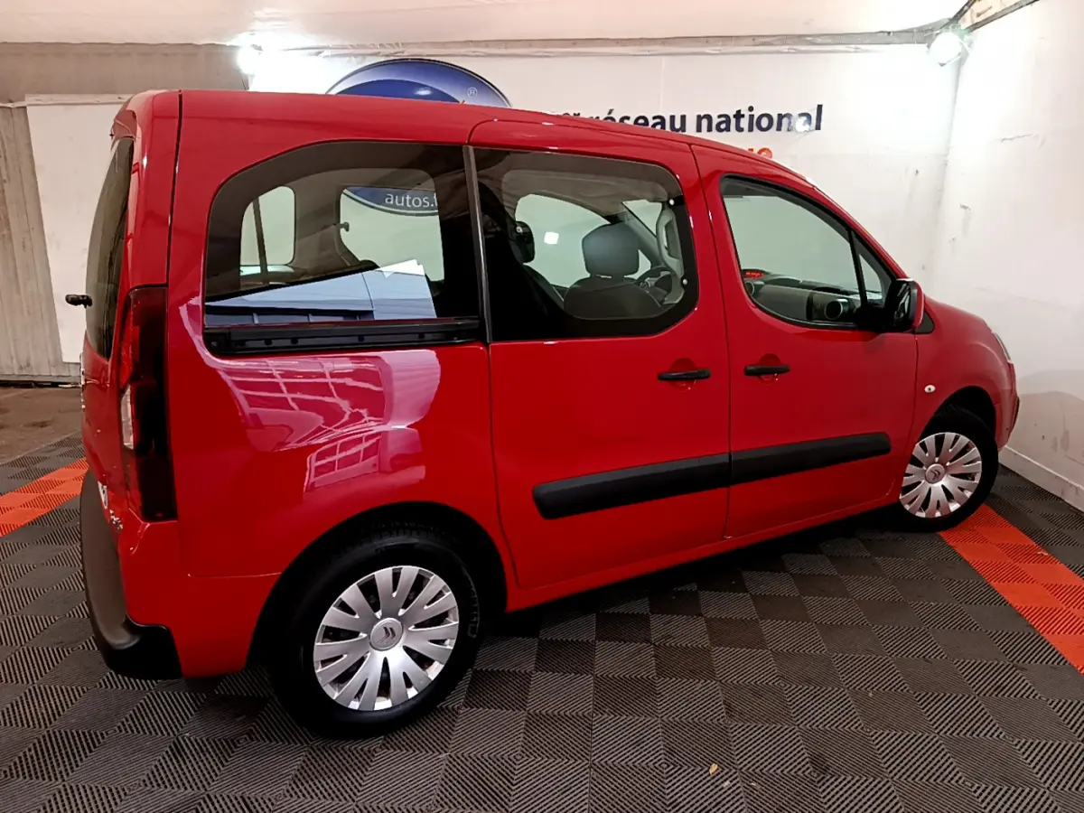 Vue 3/4 arrière droite d'un Citroën Berlingo rouge de 2016 avec vitres teintées et jantes en acier.
