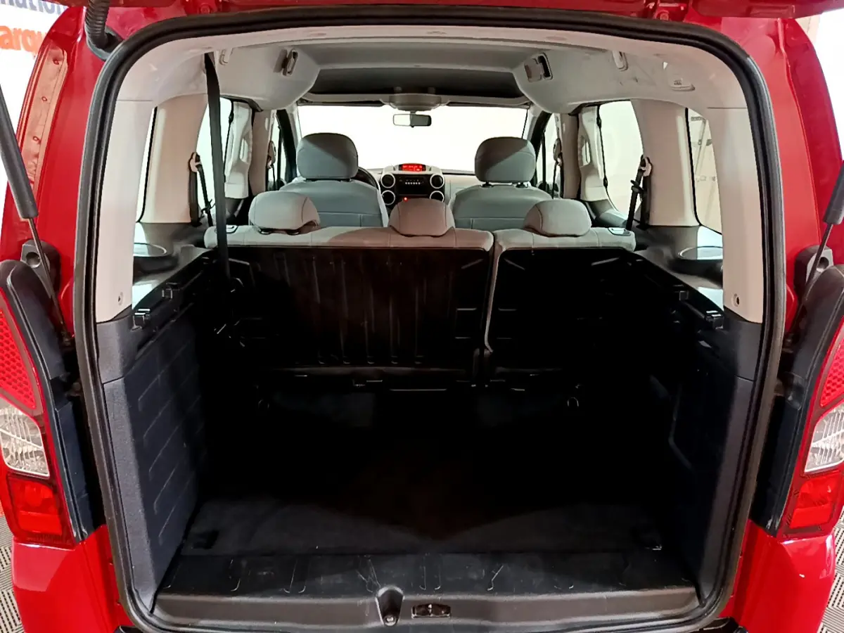 Coffre ouvert d'un Citroën Berlingo rouge 2016, vue arrière montrant l'espace de chargement et les sièges arrière.
