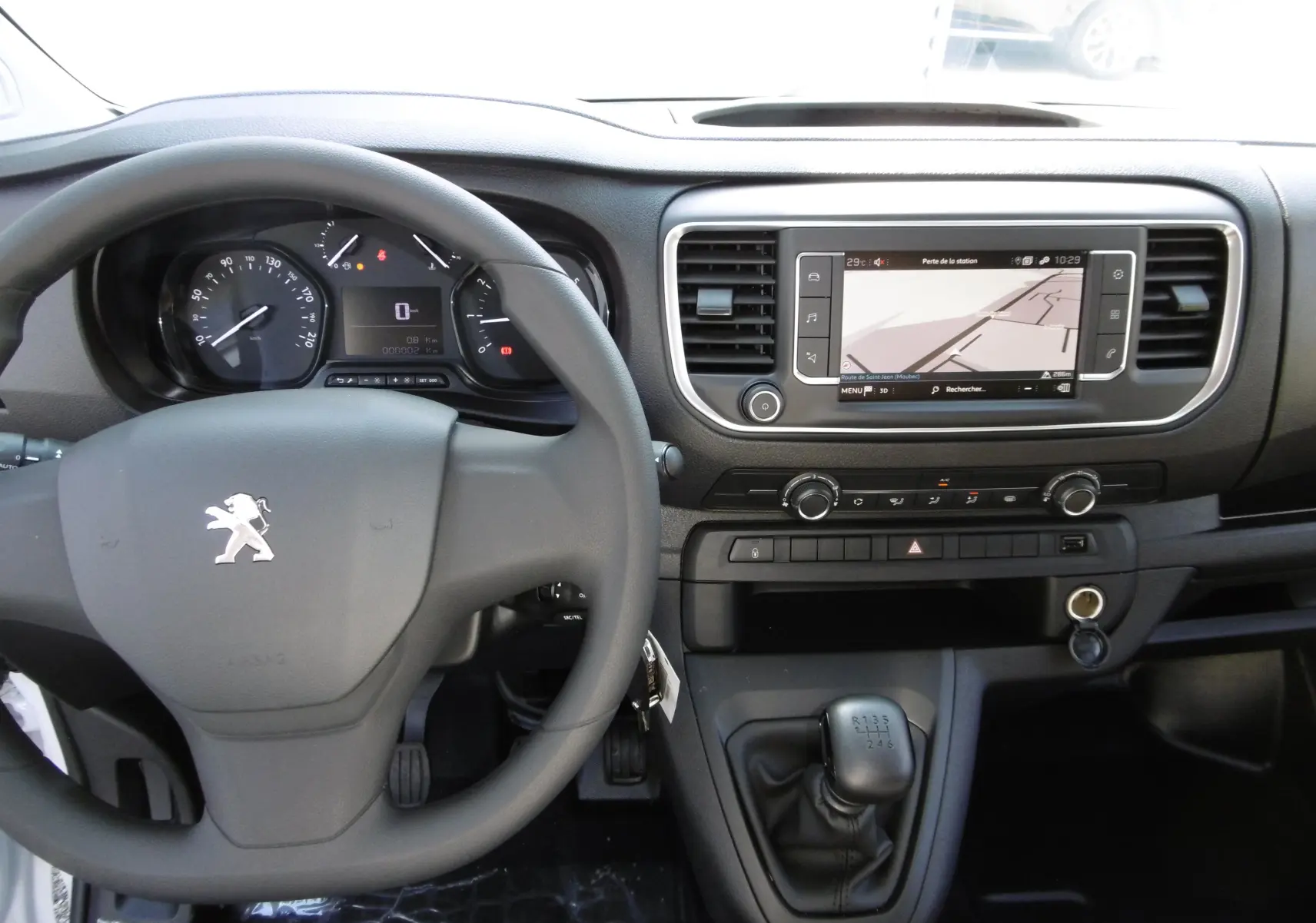 Vue intérieure du tableau de bord du Peugeot Expert Long 2023, avec volant, écran tactile et levier de vitesse manuel noir.