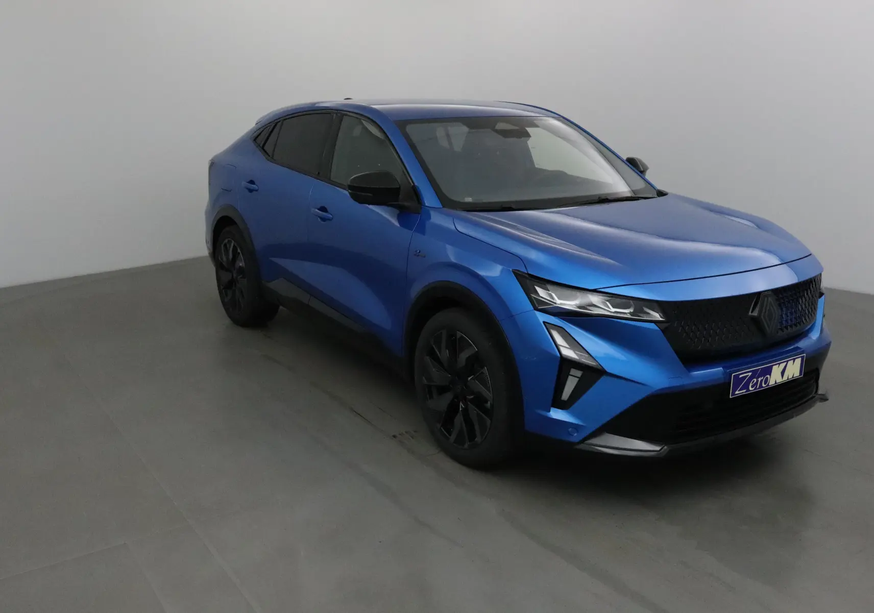 Renault Rafale bleu sommet en 3/4 avant droit, avec calandre noire et feux LED adaptatifs modernes.