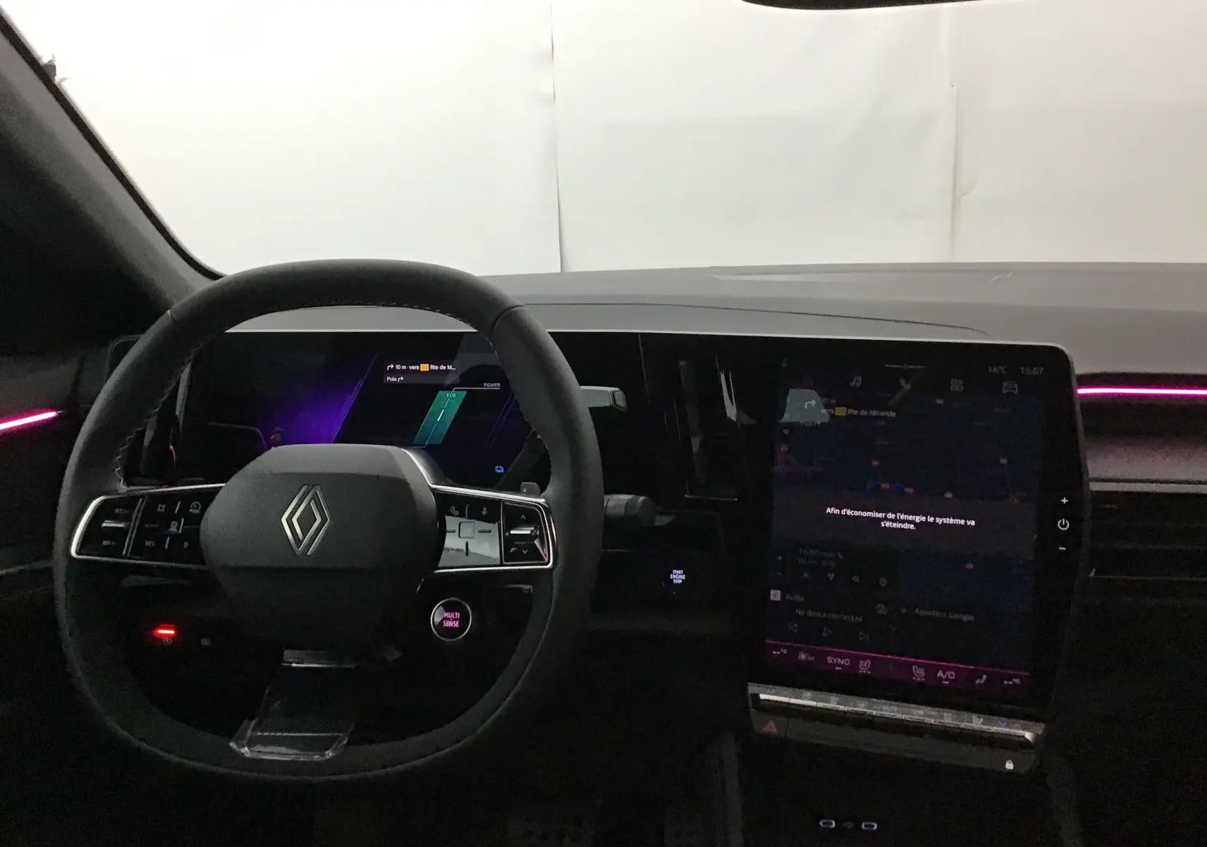Intérieur Renault Rafale 2025 en vue frontale, volant multifonction, tableau de bord numérique et éclairage d'ambiance violet.