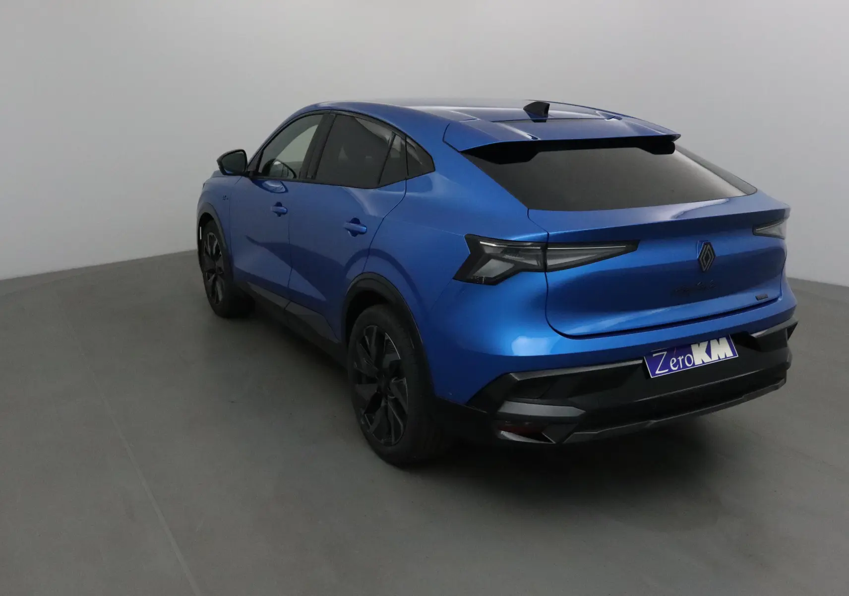 Vue 3/4 arrière droite d'une Renault Rafale bleu sommet avec feux arrière LED et toit noir lustré.