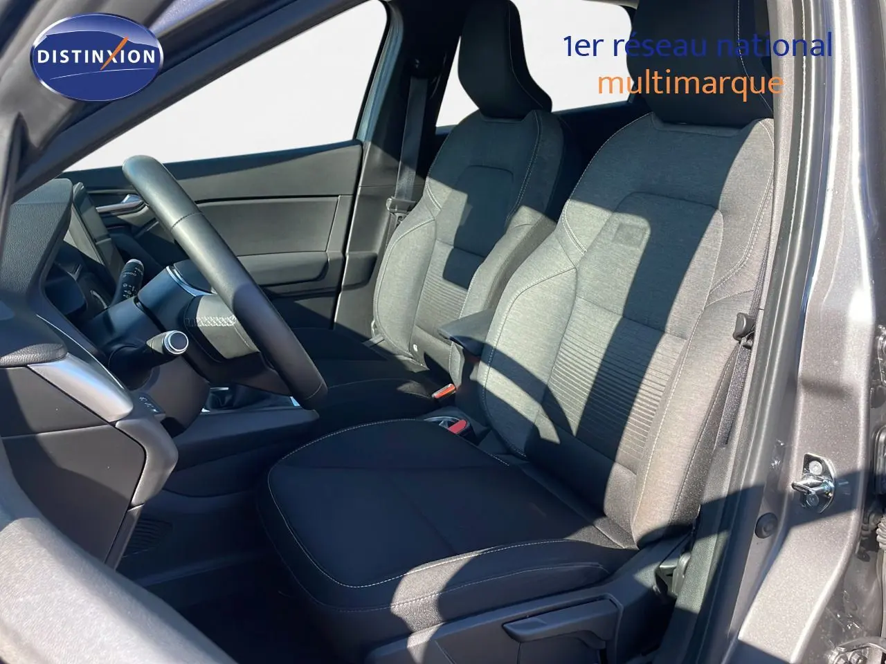 Intérieur avant du Renault Captur TCE 100CH Corporate Edition 2020, sièges tissu noir et gris, volant et tableau de bord visibles.