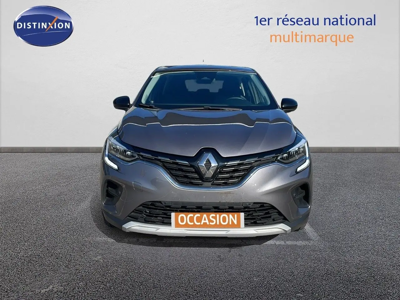 Vue frontale d'un Renault Captur TCE 100CH Corporate Edition gris cassiopée métal avec feux LED allumés.