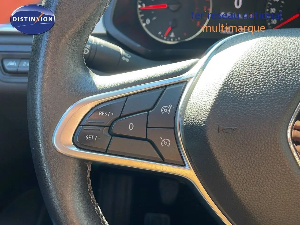 Gros plan sur le volant cuir noir du Renault Captur TCE 100CH Corporate Edition, avec commandes de régulateur de vitesse.