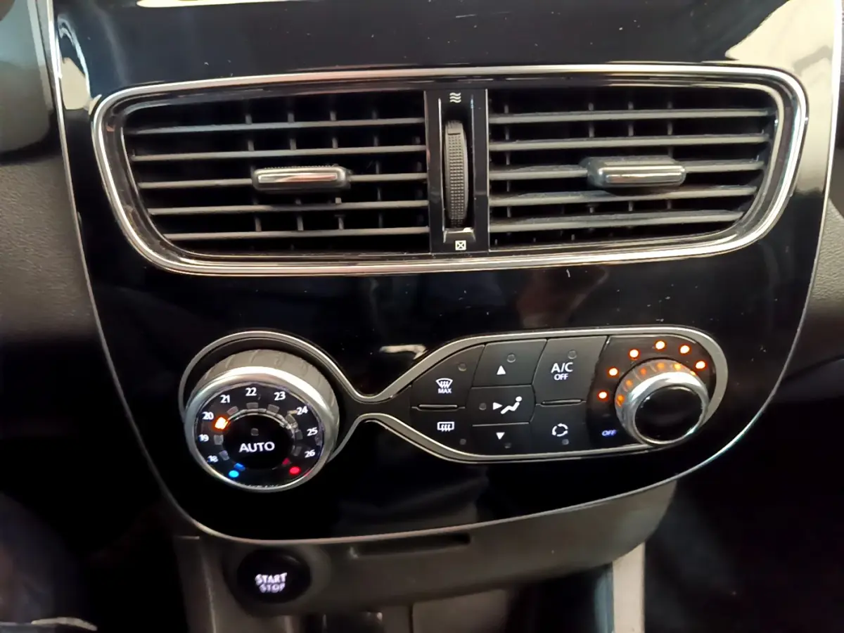 Gros plan sur la console centrale noire de la Renault Clio Business TCe 90 avec commandes de climatisation et ventilation.