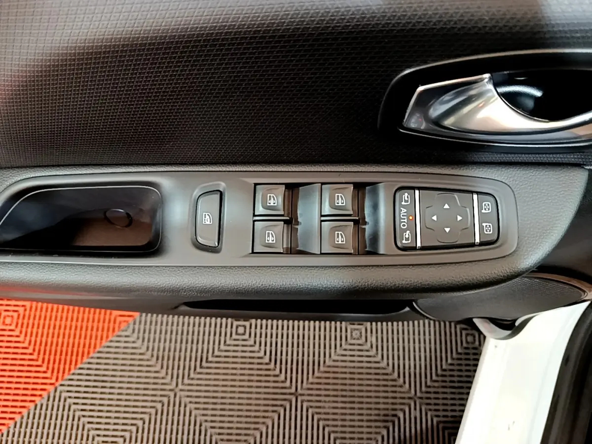 Vue rapprochée de la commande des vitres et rétroviseurs sur la porte côté conducteur d'une Renault Clio Business blanche.