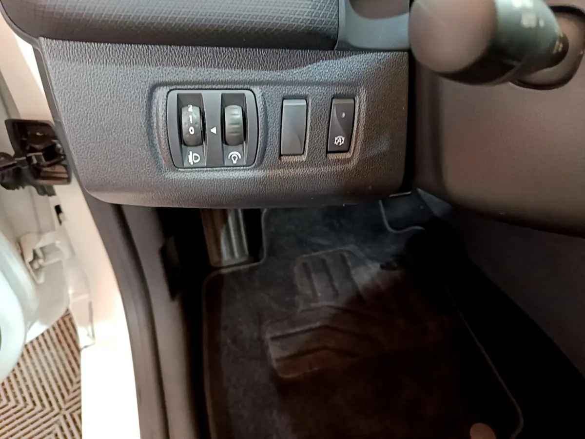 Vue rapprochée des commandes d'éclairage et du tableau de bord côté gauche dans une Renault Clio Business blanche de 2019.