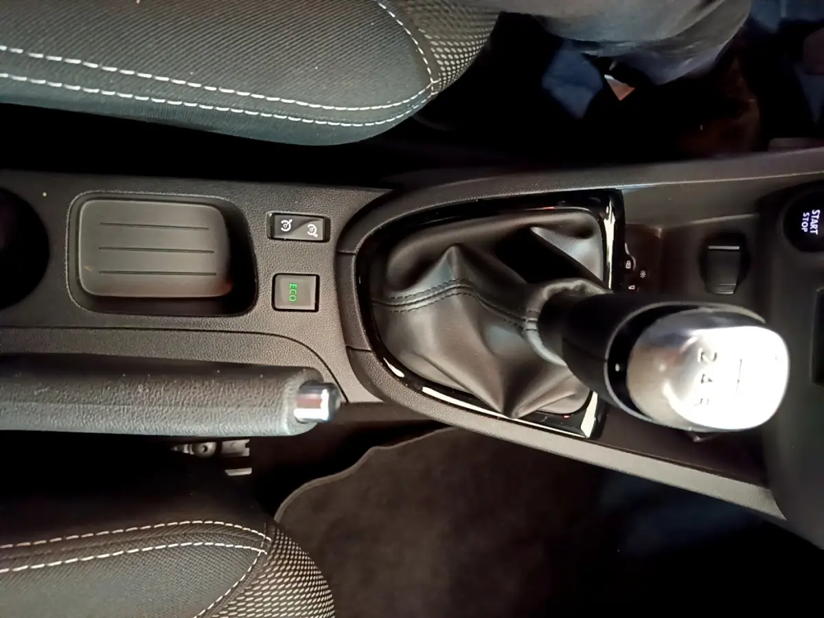 Vue rapprochée de la console centrale noire de la Renault Clio Business TCe 90, avec levier de vitesse manuel et frein à main.