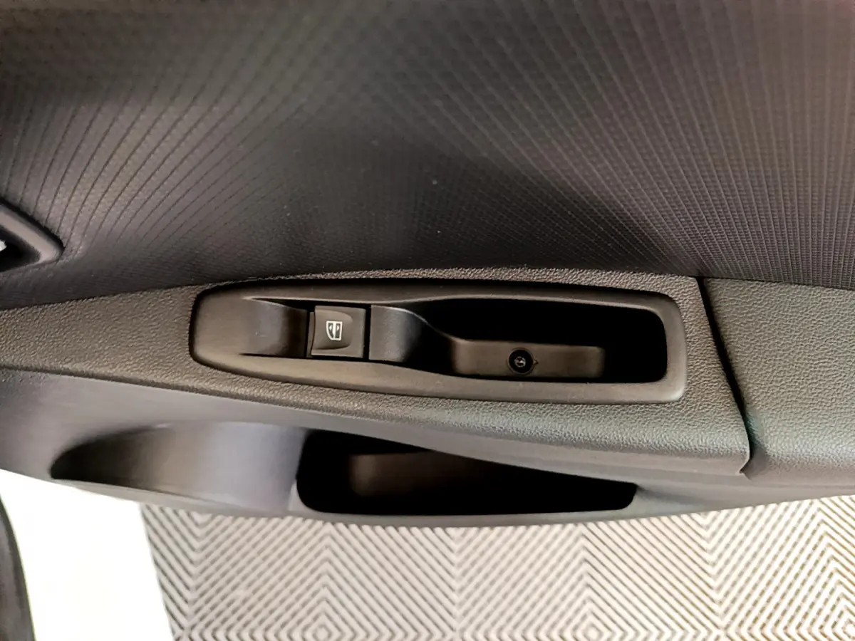 Gros plan sur la commande de lève-vitre côté conducteur de la Renault Clio Business TCe 90 blanche de 2019.