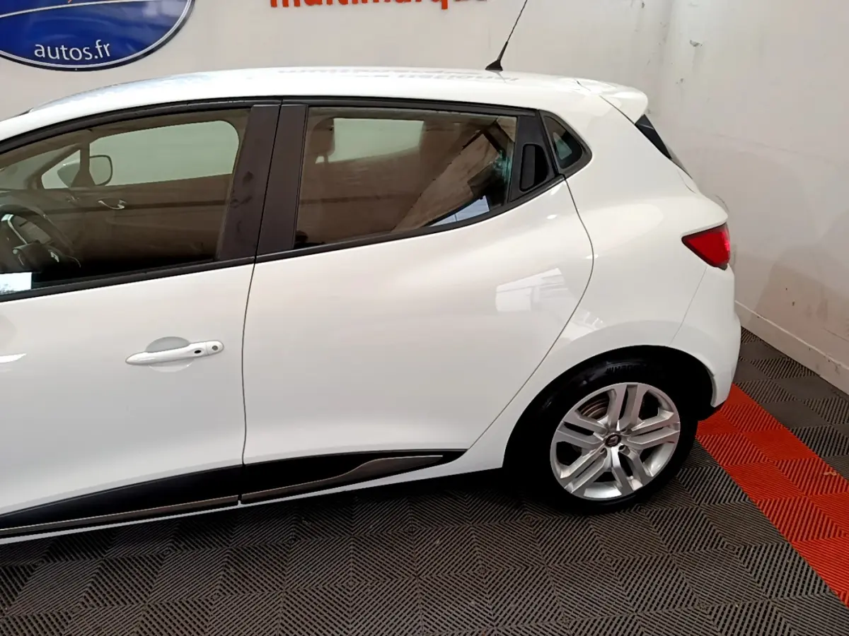 Profil côté gauche de la Renault Clio Business TCe 90 blanche, mettant en valeur ses lignes épurées et jantes alliage.
