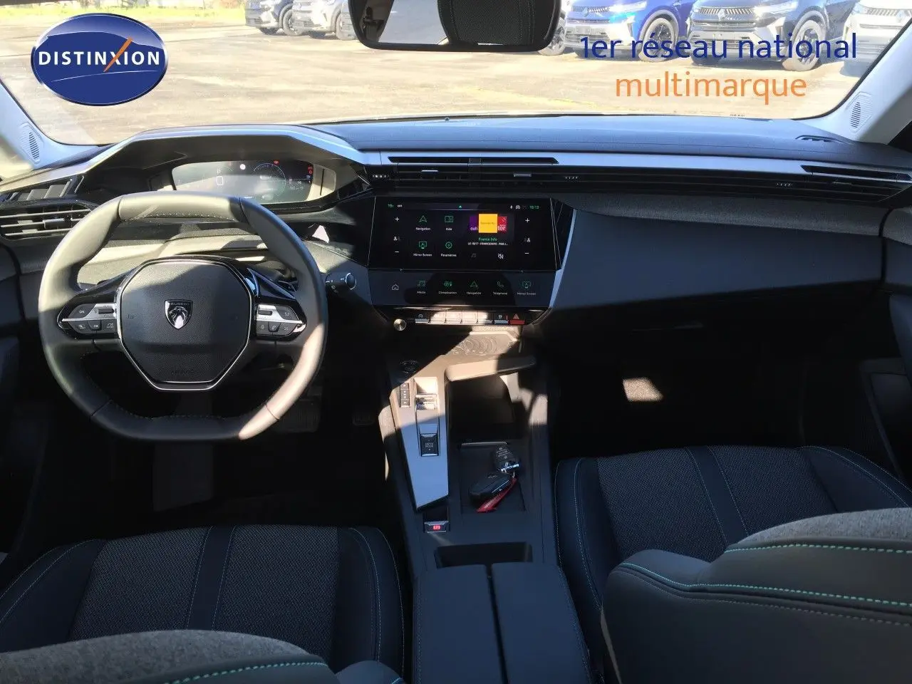 Intérieur de la Peugeot 308 2025, vue de face sur le tableau de bord et volant, ambiance sombre avec finitions noires.