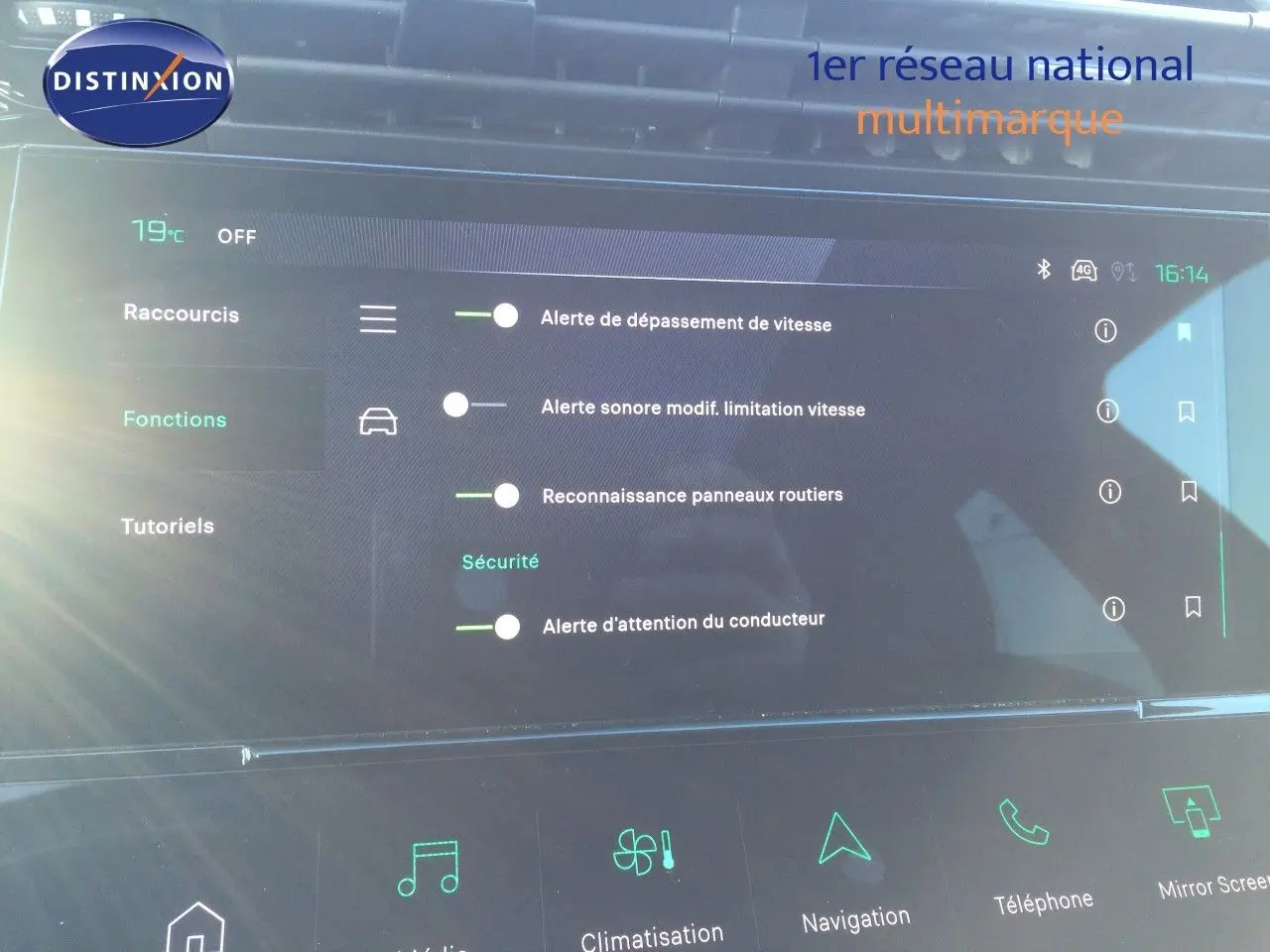 Vue de face du tableau de bord numérique de la Peugeot 308 gris Artense, affichant les alertes de sécurité et fonctions connectées.