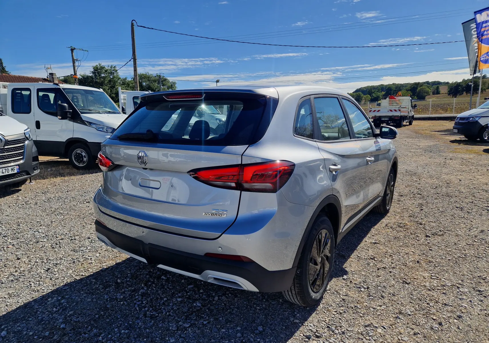 Vue 3/4 arrière droite du MG Motor 1.5 L Hybrid+ 197 ch en Cosmic Silver avec feux arrière LED et jantes acier 16 pouces.