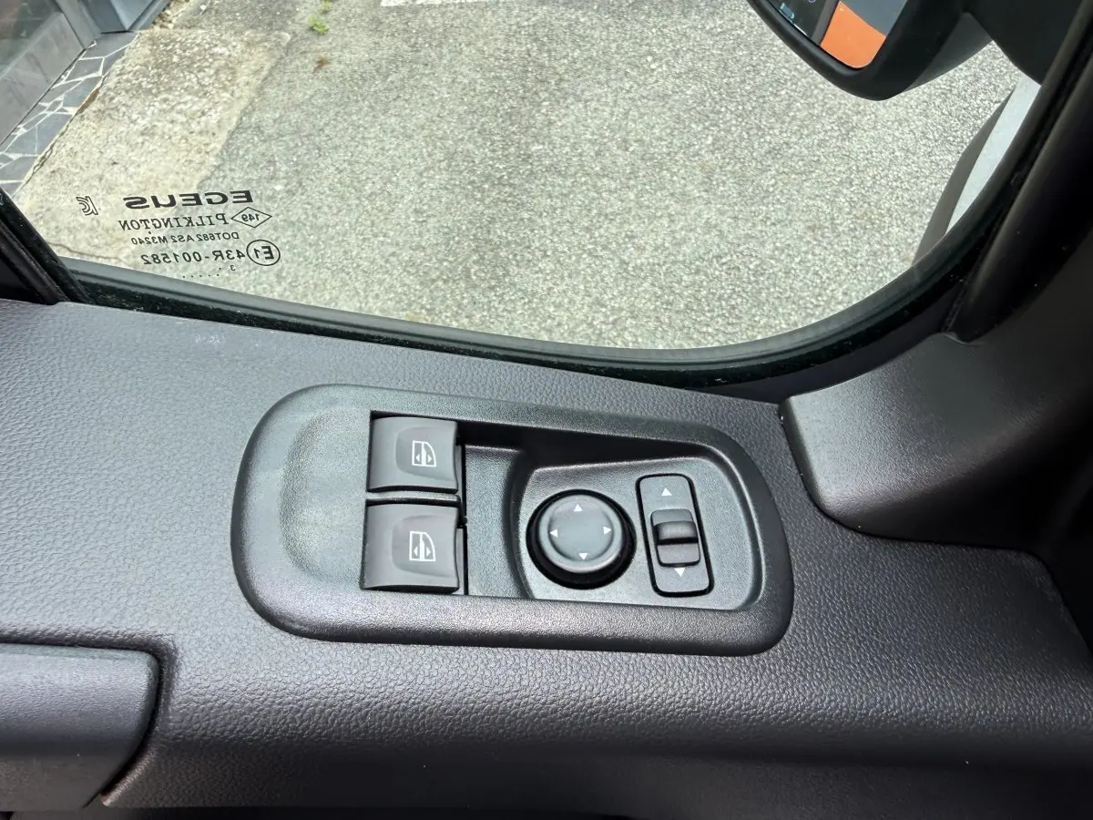 Commande des vitres et réglage des rétroviseurs côté conducteur du Renault Master blanc, vue intérieure côté gauche.