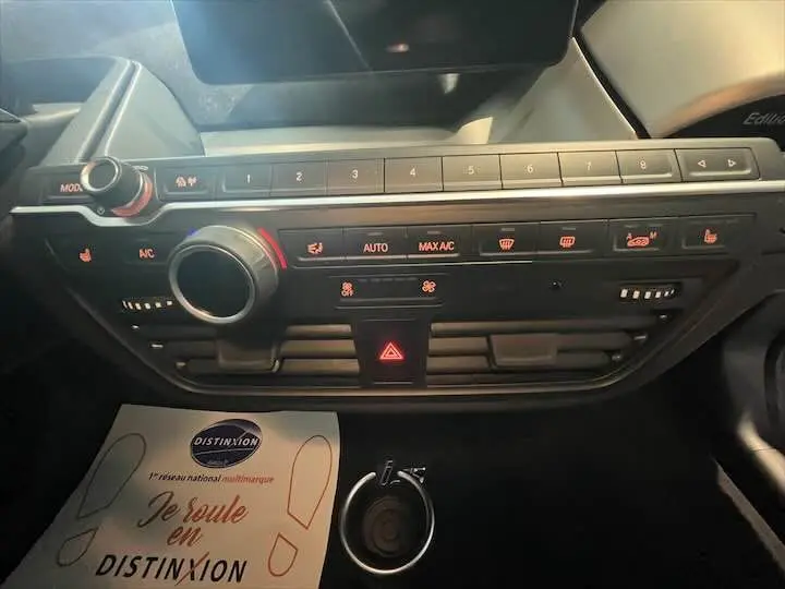 Tableau de bord noir de BMW i3 Edition Windmill 2022, avec commandes climatisation et bouton de danger éclairé.