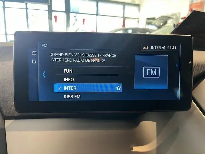 Écran multimédia de la BMW i3 2022 affichant la sélection de stations radio FM avec interface moderne.