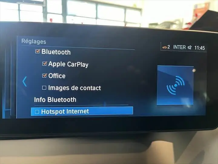 Écran multimédia de BMW i3 noir 2022 affichant les réglages Bluetooth et options connectées.