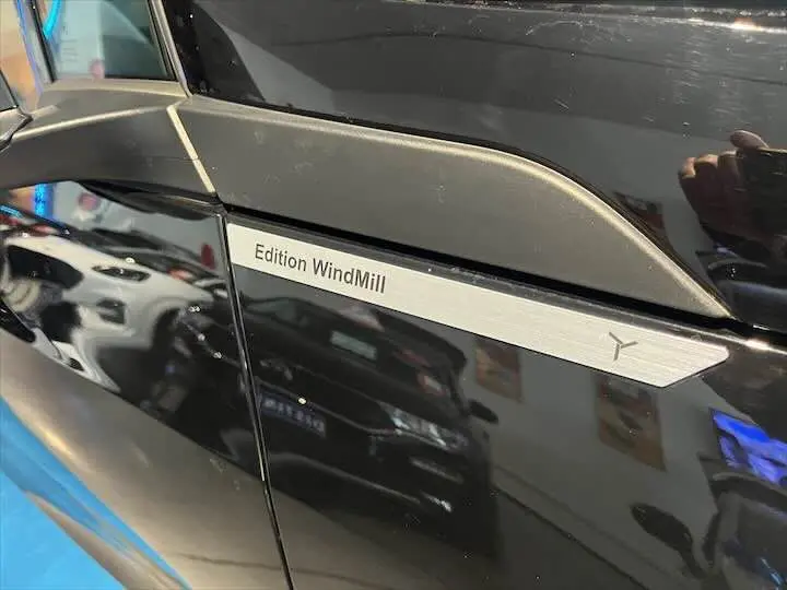 Gros plan sur l'insigne Edition WindMill sur la porte noire côté gauche de la BMW i3 électrique.