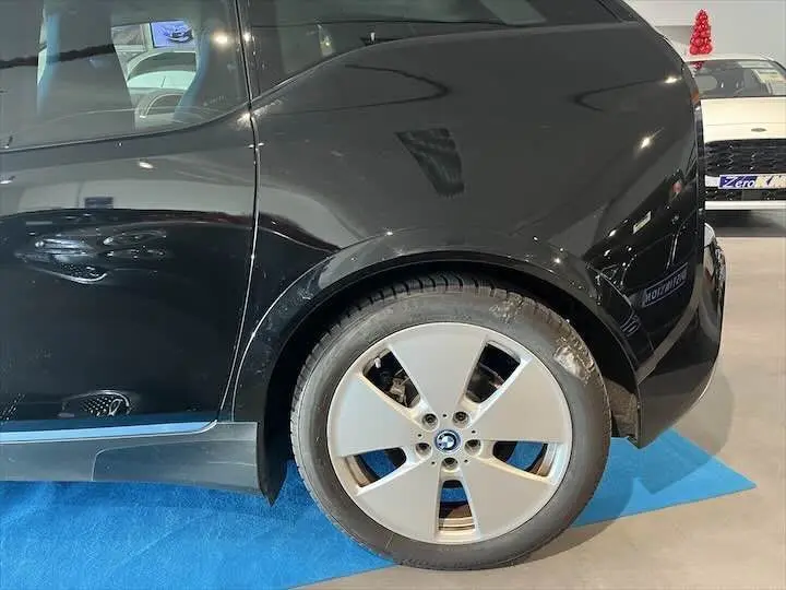 Vue latérale droite sur l'arrière noir brillant d'une BMW i3 avec jante alliage cinq branches.