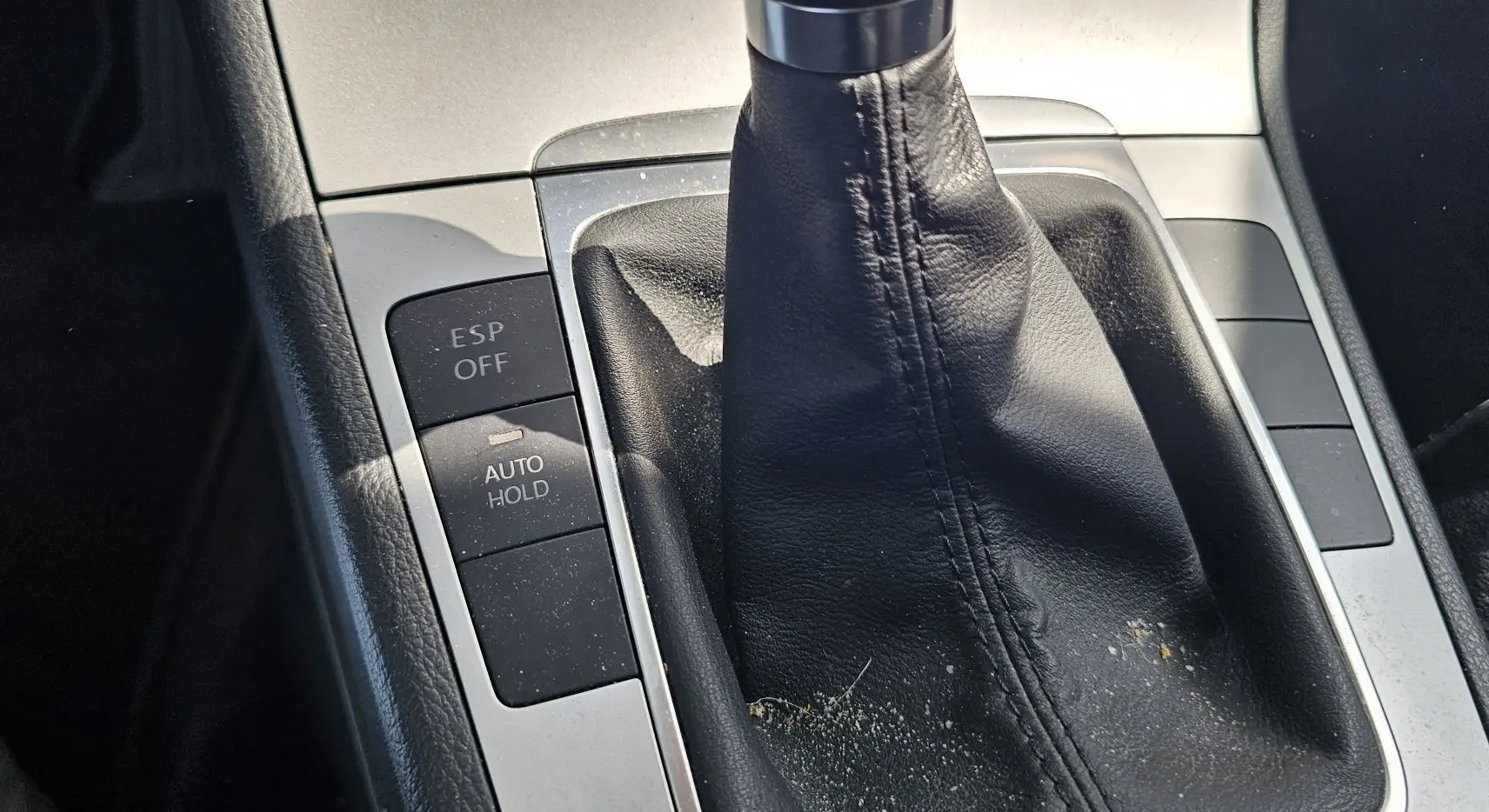 Gros plan sur la console centrale de la Volkswagen Passat bleue 2009, montrant le levier de vitesse manuel et les boutons ESP OFF et AUTO HOLD.