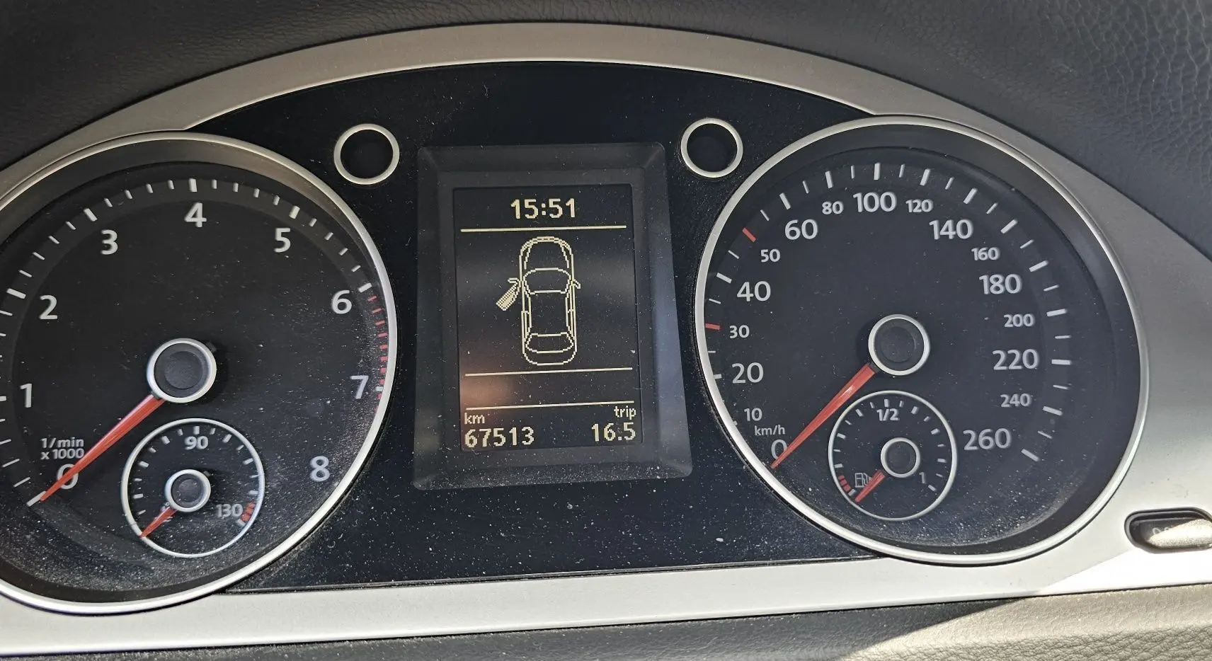 Tableau de bord de Volkswagen Passat 2009 montrant compte-tours, vitesse, niveau carburant et écran central d'information.