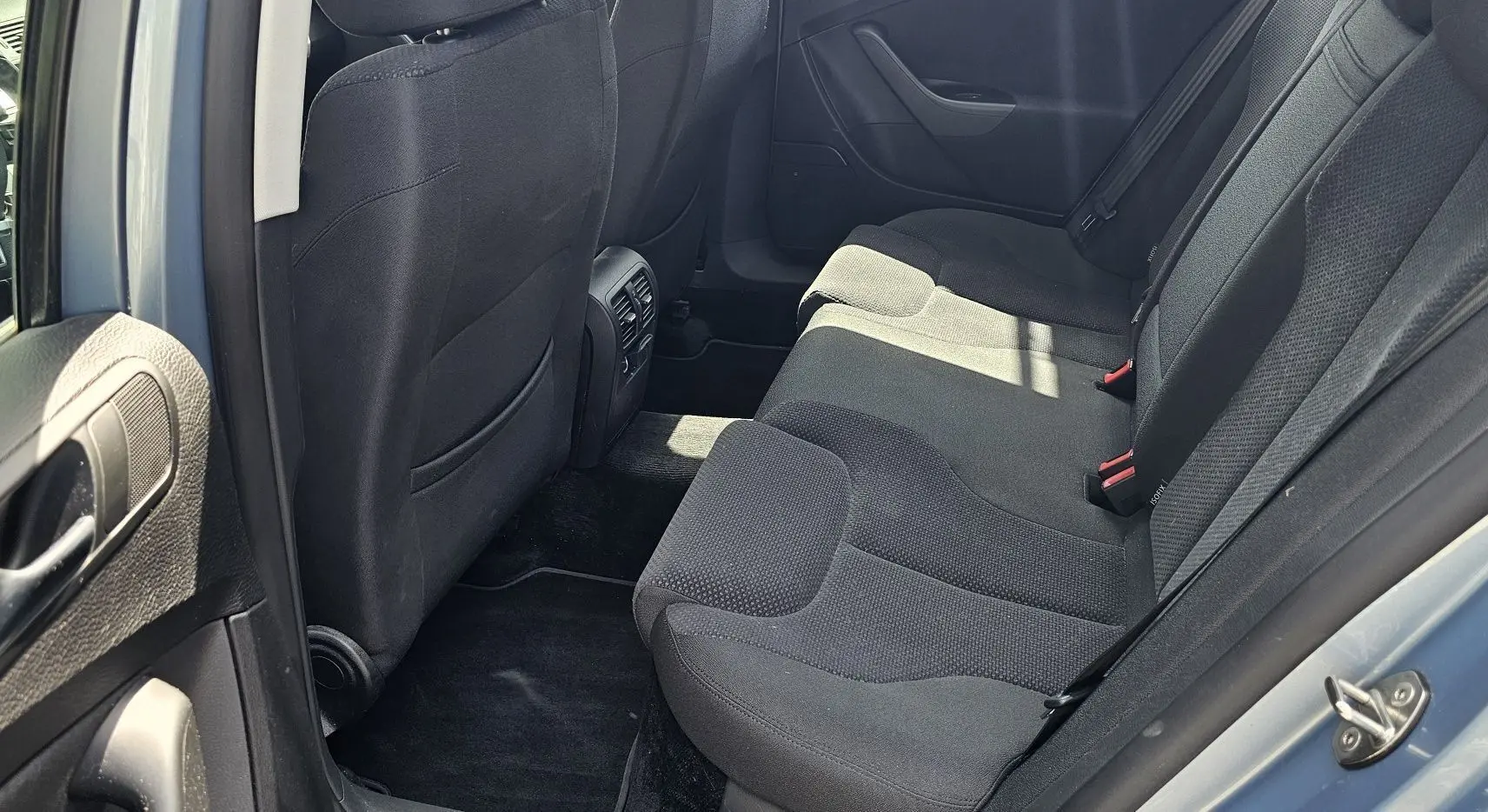 Vue intérieure côté droit sur les sièges arrière noirs d'une Volkswagen Passat 1.4 TSI bleu de 2009.