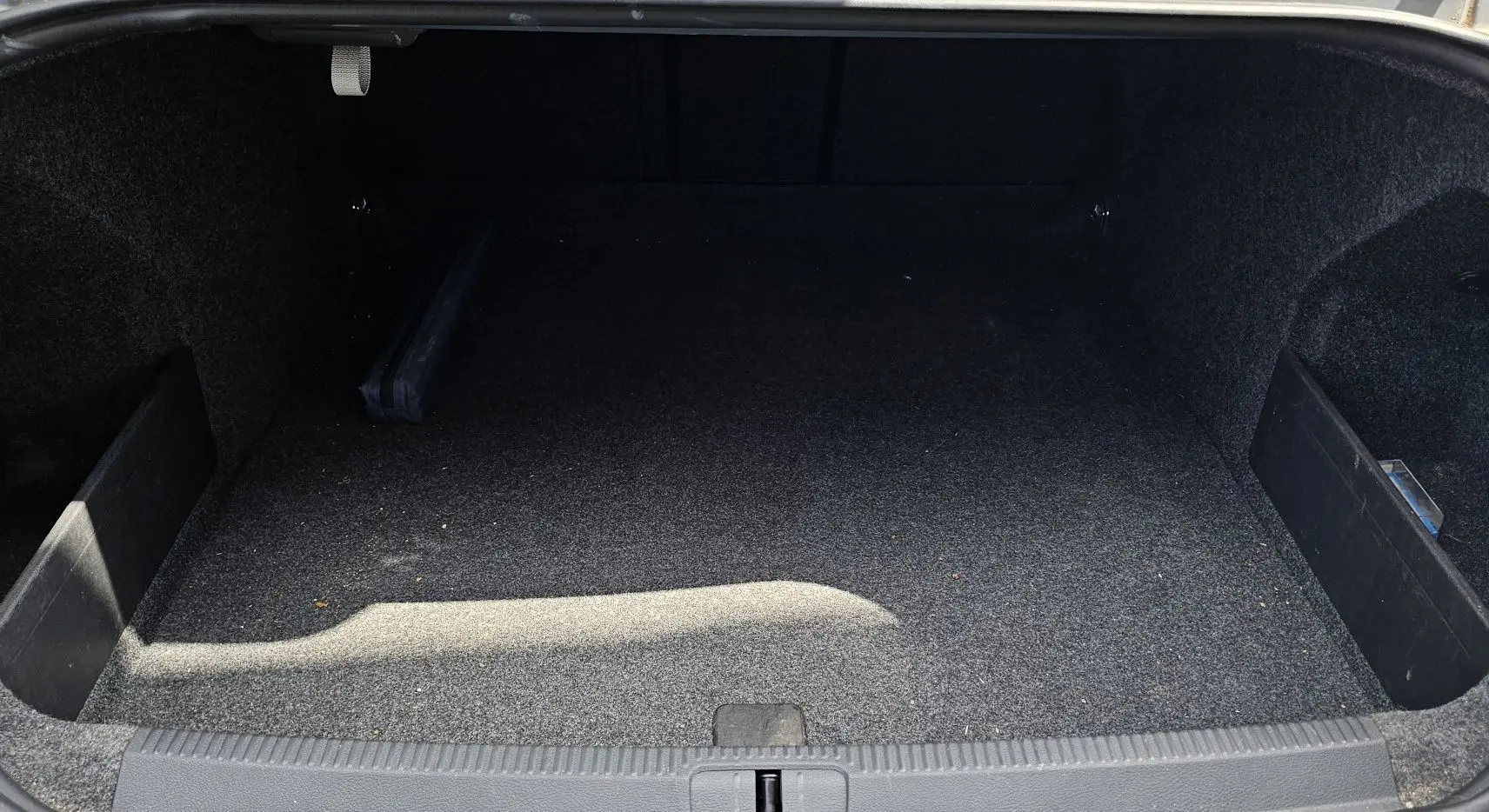 Coffre vide de la Volkswagen Passat 1.4 TSI 120 Confort bleu de 2009, vue intérieure depuis l'arrière.