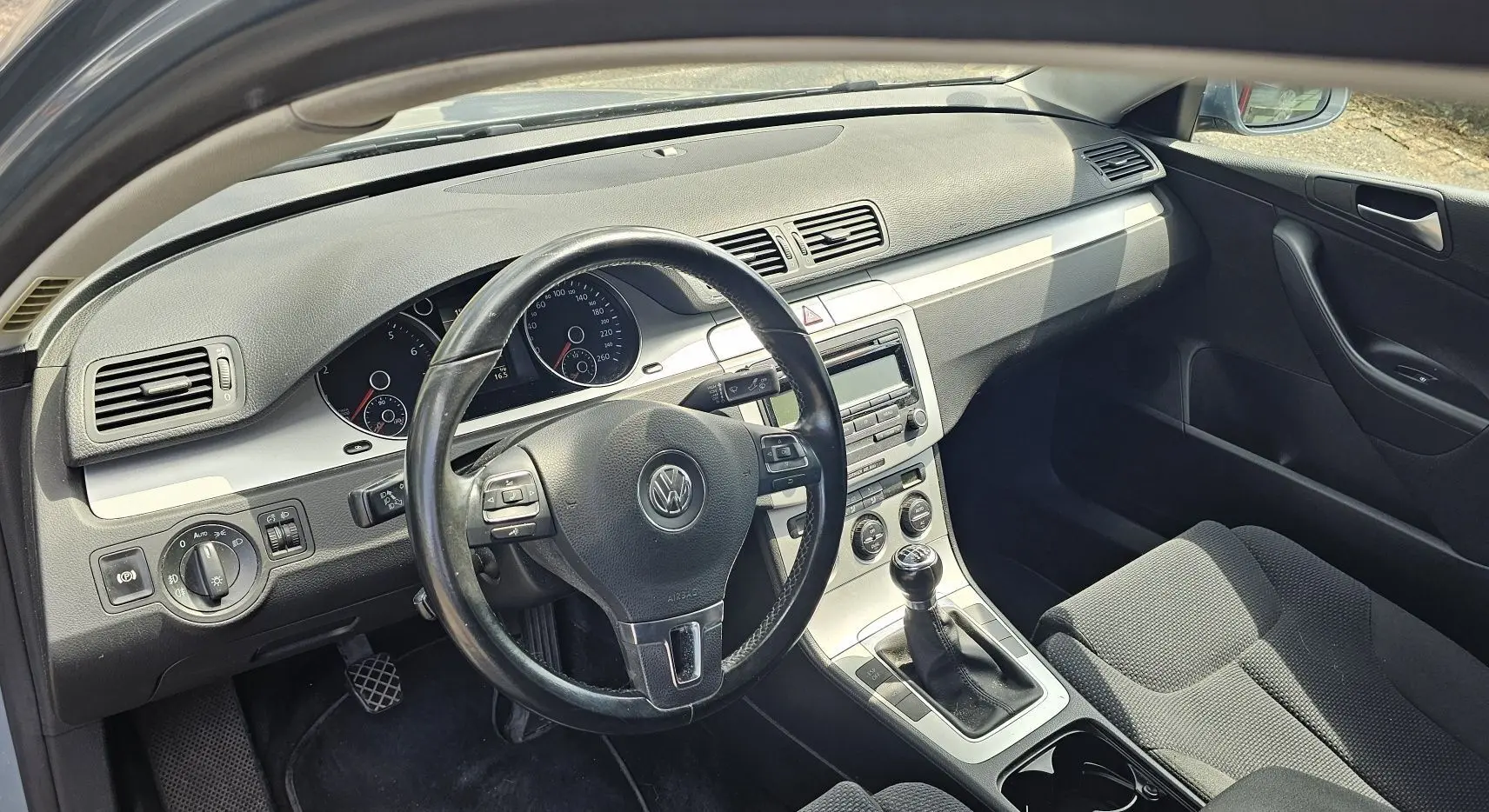 Intérieur de la Volkswagen Passat 1.4 TSI 2009, vue côté conducteur, volant cuir et tableau de bord gris.