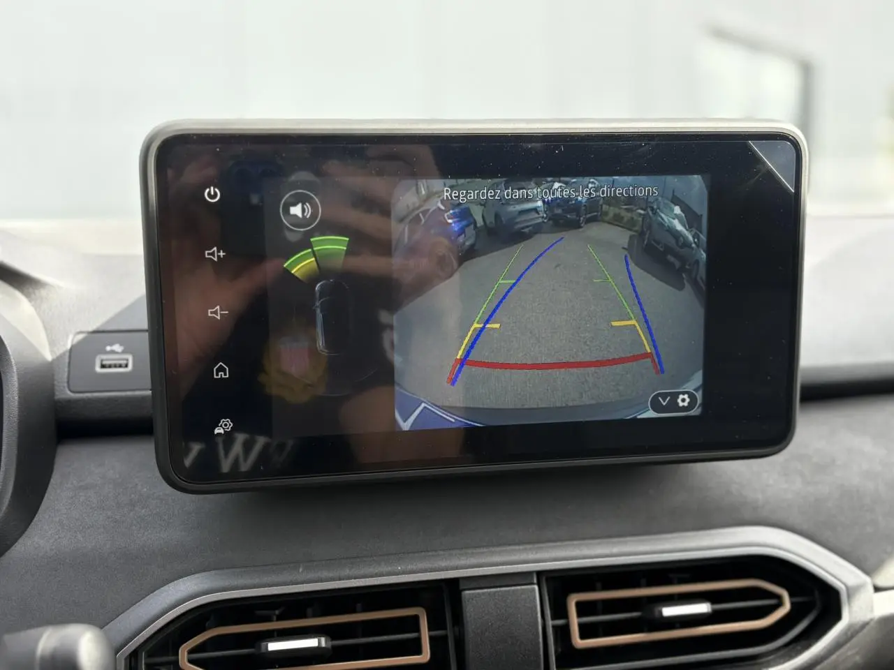 Écran tactile intérieur affichant la caméra de recul du Dacia Jogger Gris Schiste avec lignes de guidage colorées.