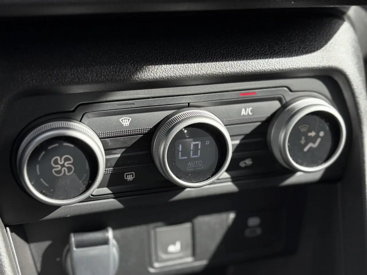 Gros plan sur les commandes de climatisation automatique du DACIA JOGGER Gris Schiste, affichant 16°C en mode AUTO.