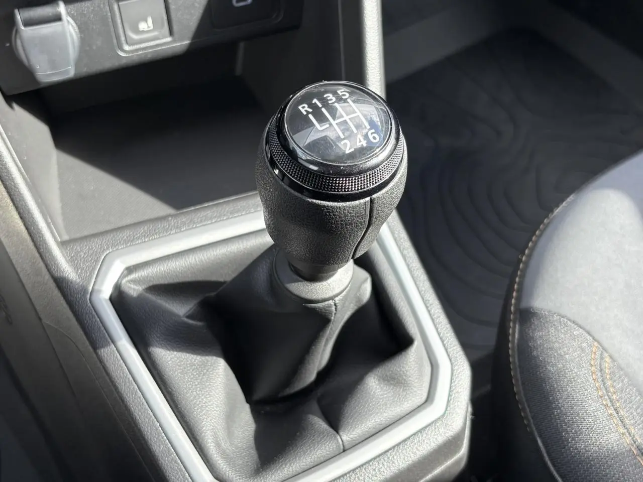 Le levier de vitesses manuel noir du Dacia Jogger gris Schiste, vu en gros plan depuis l'avant droit de l'habitacle.