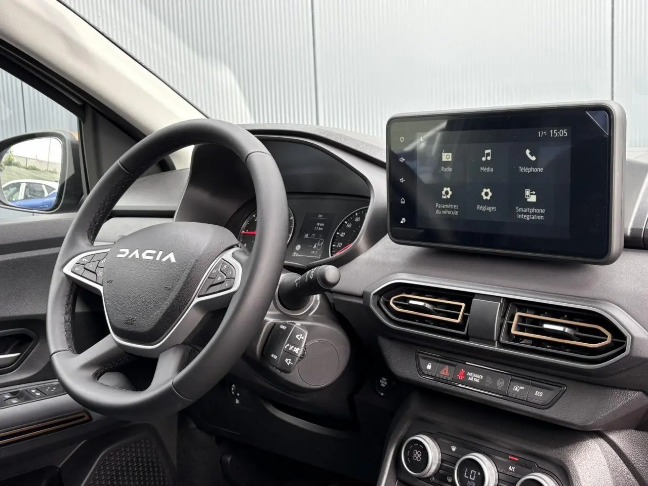 Vue intérieure du tableau de bord du Dacia Jogger gris, avec volant multifonction et écran tactile central 8 pouces.